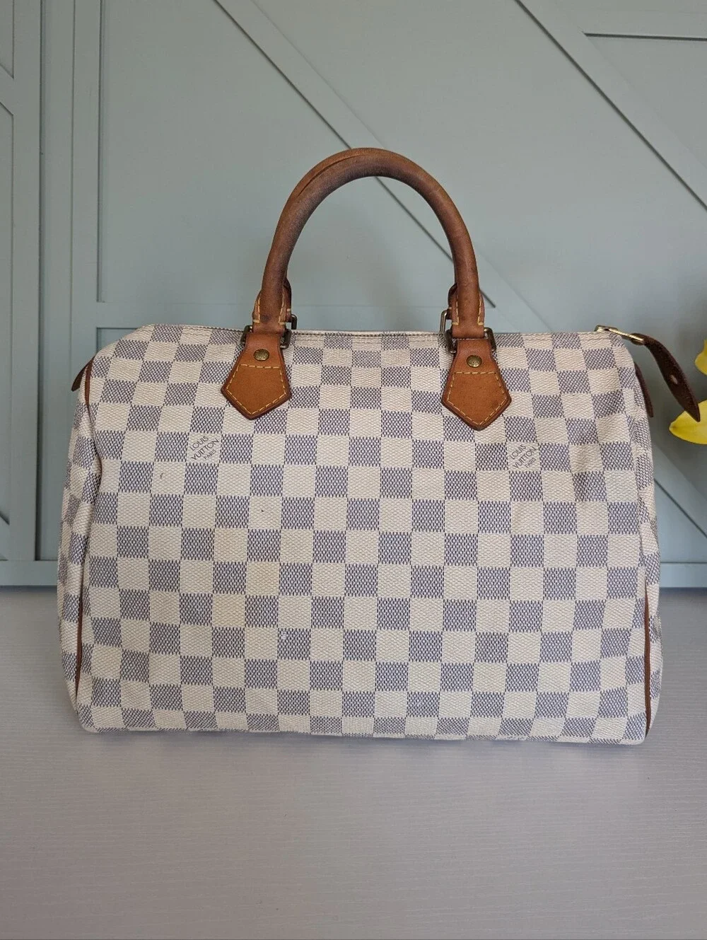 Louis Vuitton Speedyhandbag styled in the iconic Damier Azur canvas pattern.